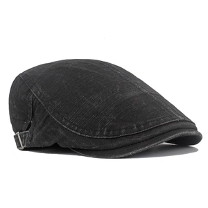 Detail of washed black cotton newsboy cap featuring side metal buckle and twill texture