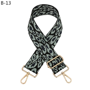 Macro detail of adjustable leopard print bag strap with polished gold-tone metal hooks