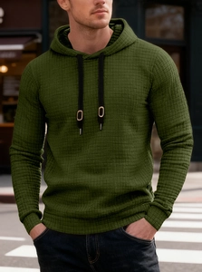 Outdoor street style view of moss green waffle knit hoodie with black drawstring