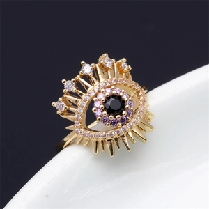 Detail of gold evil eye ring with purple and white zircon inlays and spiked texture