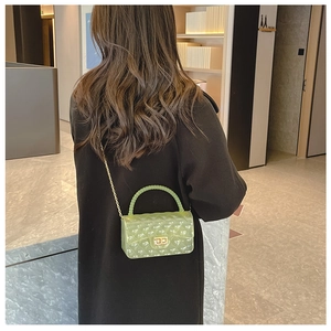 Detail of transparent green jelly bag with quilted pattern and gold chain strap