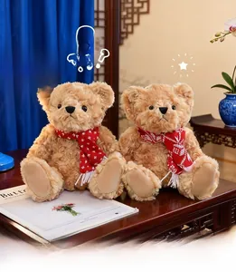 Close-up of two brown teddy bears with curly plush fur wearing red snowflake scarves