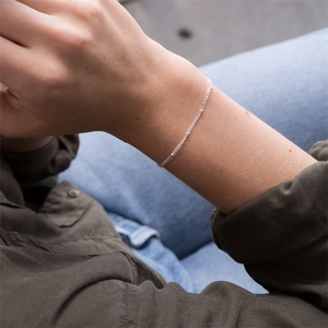 Elegant minimalist silver chain bracelet for women on wrist in casual lifestyle setting