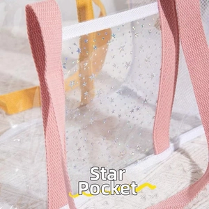 Detail of transparent PVC beach bag with glittery stars and pink woven handle straps
