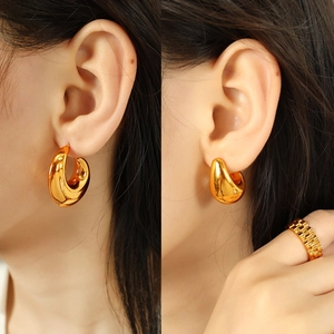Golden teardrop earrings and watch-band style ring set with a polished metallic finish