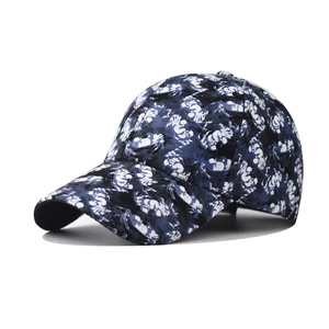 Detailed view of canvas baseball cap with blue abstract floral ink pattern and curved brim