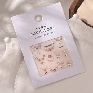 Macro detail of MJ-041 nail jewelry with pink rhinestones and silver heart charms