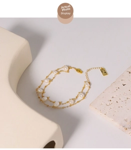 Detailed close-up of a double-layer freshwater pearl bracelet with golden chain and lobster clasp