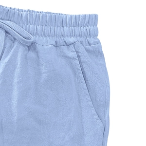 Close-up of light blue linen shorts featuring an elastic drawstring waist and side pockets