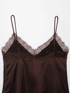 Détail d'un caraco en satin marron foncé avec bordure en dentelle cil et texture soyeuse