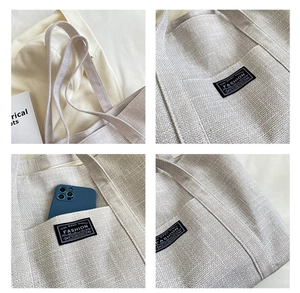 Detail view of linen tote bag with Fashion embroidery and functional pockets