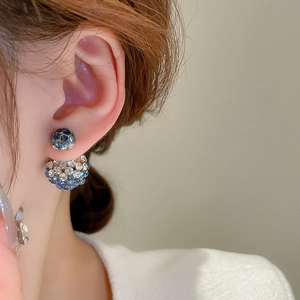 Detail of elegant blue and white rhinestone double ball earrings worn by model