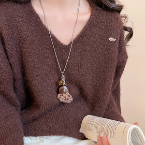 Détail du collier coeur vintage avec pendentif mini chapeau et motif léopard élégant