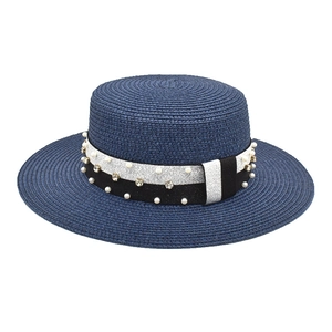 Detail of navy blue straw boater hat featuring pearl and rhinestone ribbon embellishment