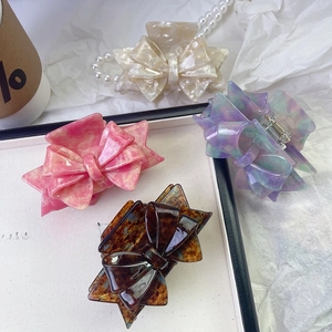 Set of four luxury acetate bow hair claws in beige, pink, gradient, and tortoiseshell