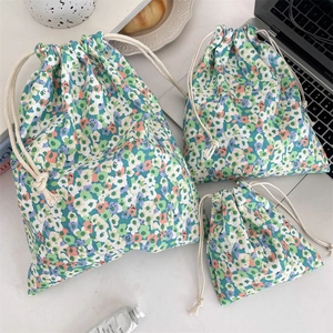 Three sizes of floral drawstring storage bags with canvas texture in a lifestyle scene