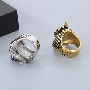 Detailed close-up of a gold punk style wolf head and Anubis scale embossed steel ring