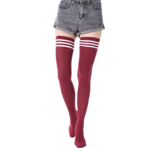 Détail de chaussettes hautes bordeaux avec trois rayures blanches en coton tricoté