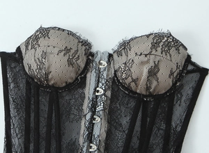 Close-up of black lace corset with beige cups and front metal hook-and-eye closure
