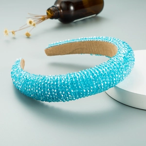 Detail of light blue crystal beaded wide headband on a display stand with velvet lining