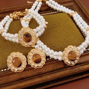 Set gioielli vintage con pietre occhio di tigre e perle su elegante sfondo in velluto oliva