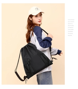 Detailansicht des schwarzen Oxford-Stoff Kordelrucksacks mit Fronttasche und Netztaschen.
