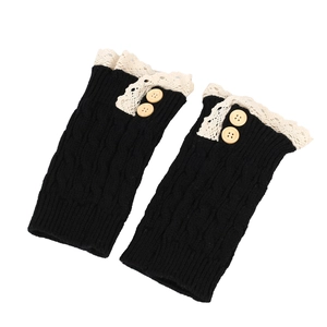 Detail of black knitted leg warmers with delicate white lace trim and beige buttons