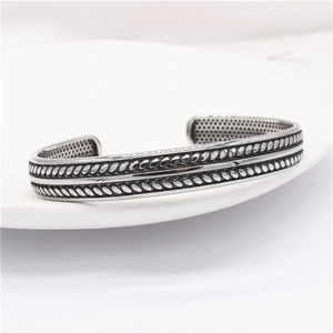 Close-up of vintage eagle-style open bangle with twisted rope texture in retro silver finish