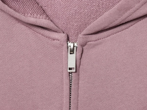 Gros plan sur la fermeture éclair et la capuche du sweat à capuche en coton lilas