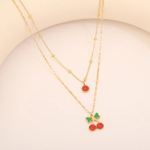 Gros plan du collier doré double épaisseur avec pierre rouge et cerises