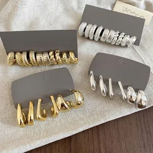 Gold and silver irregular C-shape drop earrings set with textured hoop designs