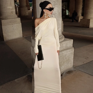 Close-up of elegant off-shoulder beige maxi dress with smooth draping fabric texture