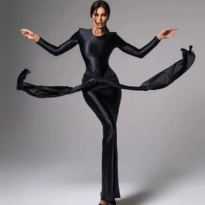 Détail d'une robe maxi en satin noir à manches longues avec ceinture et texture brillante