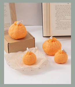 Detalle de velas perfumadas con forma de naranja y textura de piel cítrica realista