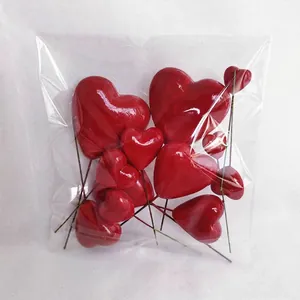 Macro detail of assorted red heart-shaped craft picks in clear plastic packaging