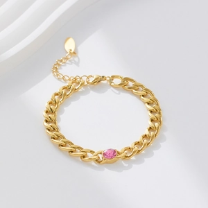 Vintage Cuban chain bracelet in gold finish with a pink zircon centerpiece on white background