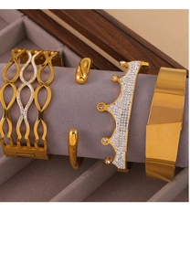 Macro detail of 18K gold plated bangle set featuring polished and geometric designs