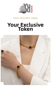 Detail of chunky gold chain jewelry set with square black stones worn with white suit