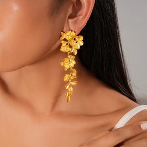 Vue détaillée des boucles d'oreilles fleurs dorées en cascade avec fini mat