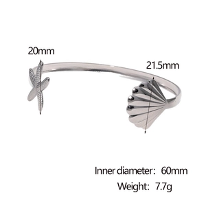 Detailed macro shot of silver starfish and seashell elements on a minimalist open bangle