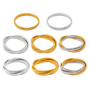 Detail of flexible spring bracelets in gold and silver metal arranged in a grid