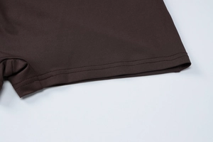 Macro detail of dark brown knit fabric with reinforced double stitching and elastic hem
