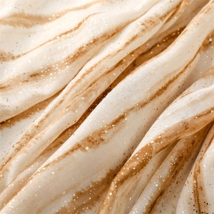 Detail of soft linen-touch scarf featuring gold foil bamboo pattern and gradient texture