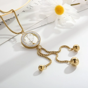 Detailed view of a gold sweater necklace with crystal pendant and tassel chain detail