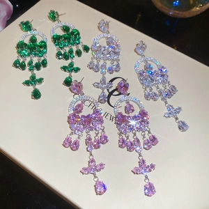 Close-up of sparkling heart drop earrings with colorful zircon stones in a jewelry box