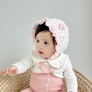 Detail of pink lace baby sun hat featuring ruffled edges and handmade 3D floral accents