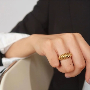 Macro detail of a gold-plated croissant dome ring with an elegant twisted texture