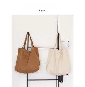 Detailed display of large canvas tote bags in caramel brown and off-white colors