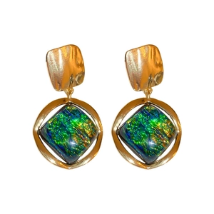 Vintage geometric gold hoop earrings with green and blue resin squares on white background