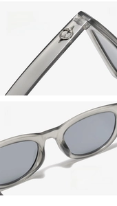 Detail of grey translucent sunglasses featuring silver metal decor and curved temples